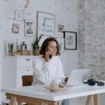 Guía realista sobre cómo empezar un negocio de dropshipping, mostrando el escritorio de un emprendedor con un portátil, libreta y cajas de envío.