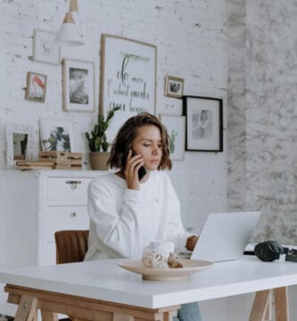 Guía realista sobre cómo empezar un negocio de dropshipping, mostrando el escritorio de un emprendedor con un portátil, libreta y cajas de envío.